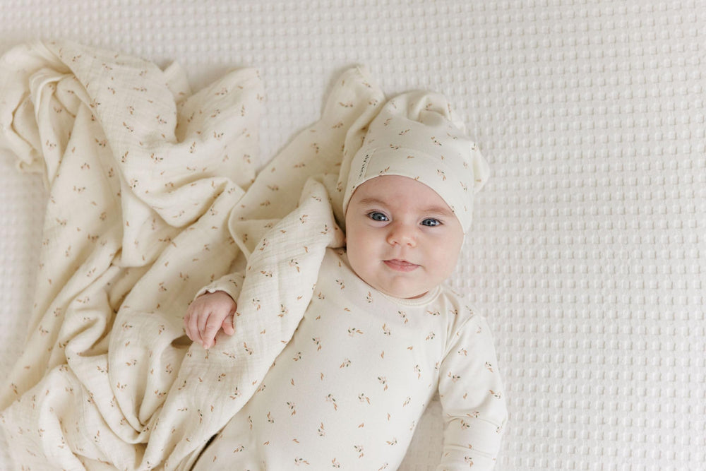Gift-ready Ely's & Co. cream floral swaddle with packaging for baby showers.
