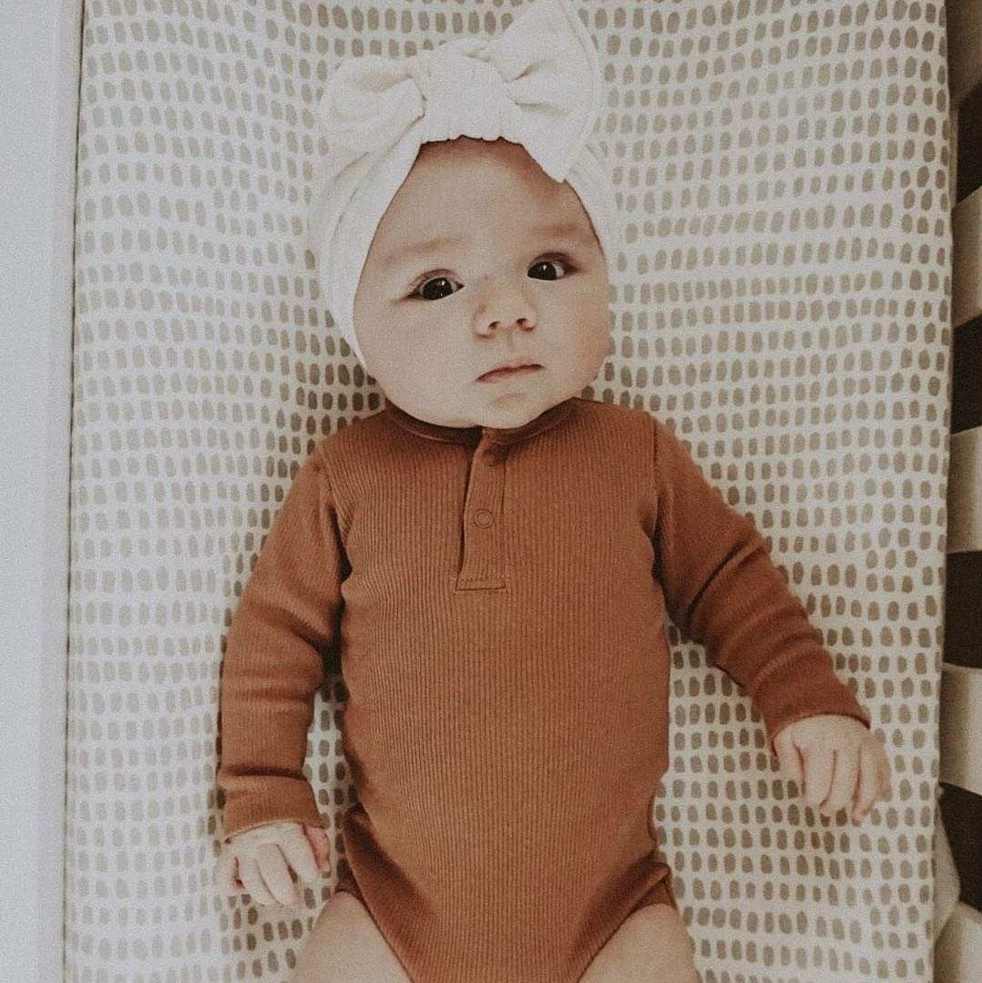 Taupe-grey nursery vibe with practical protection for diaper changes.