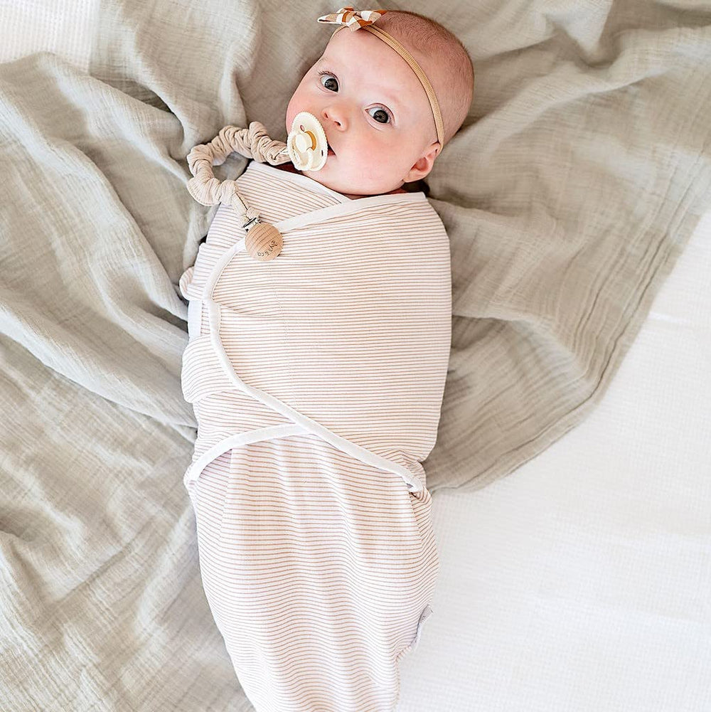Adjustable wings highlight secure fit for peaceful sleep in Ely's & Co swaddle.