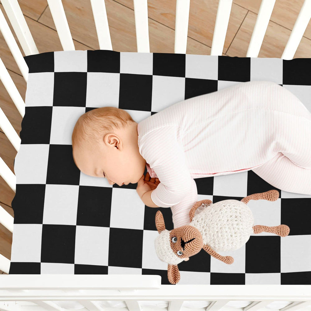 Bright checkerboard plaid crib sheet brightening a nursery with Emelivor