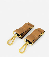 FAWN DESIGN tan stroller hooks on strapped stroller, reliable daily carrier.