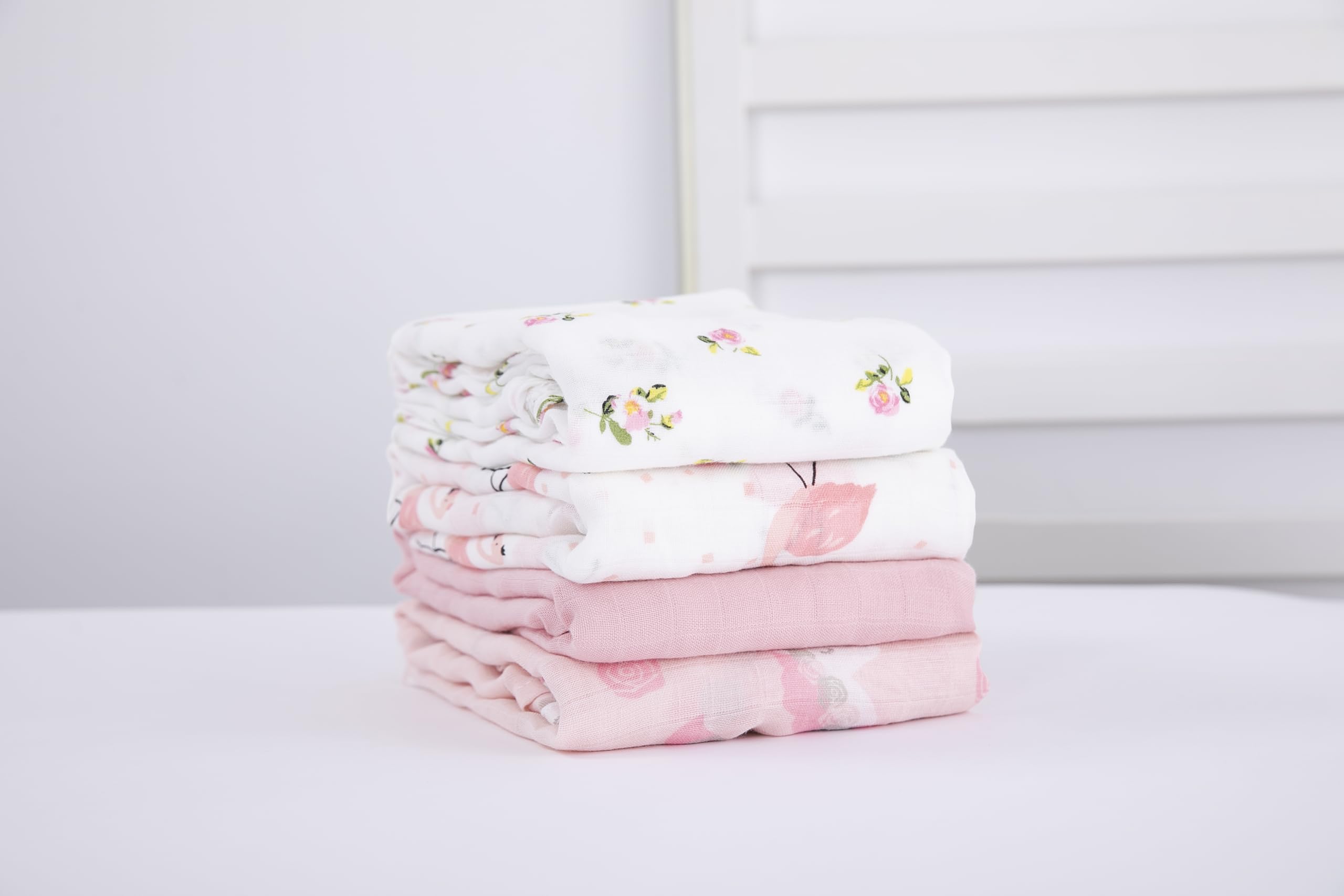 Flexora Muslin Swaddle Blanket Pink Dreams wrapped around a sleeping newborn.