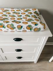 Florida Kid Co. Orange Blossom cover highlights snug elastic fit for secure diaper changes.