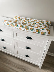 Florida Kid Co. Orange Blossom fitted cover on a changing pad promotes quick cleanup after messes.