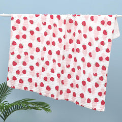 FOMAISELF Strawberry muslin blanket used as a newborn swaddle for comfort