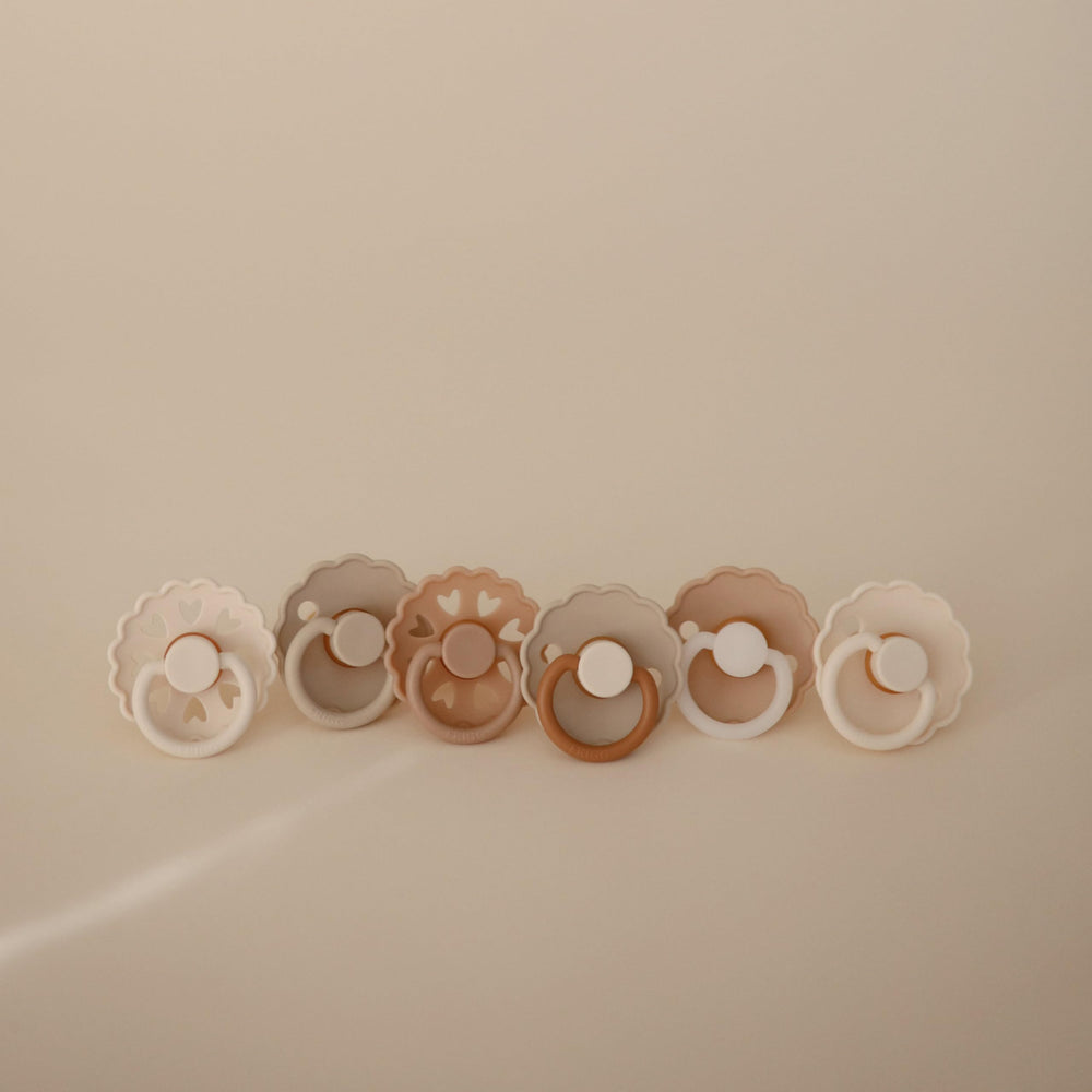 FRIGG Cinnamon Charm pacifier back view demonstrates secure handle for easy grasp.