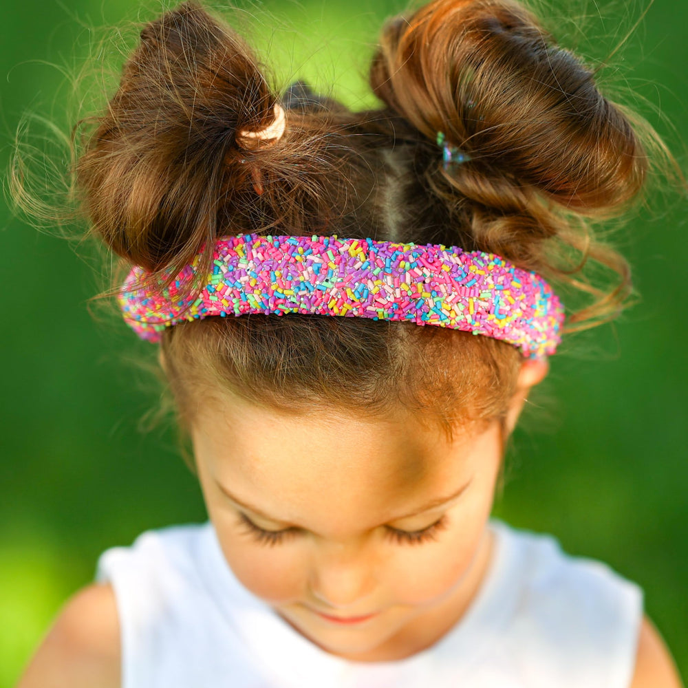 FROG SAC sprinkle headband on a girl highlights bold fashion flair.