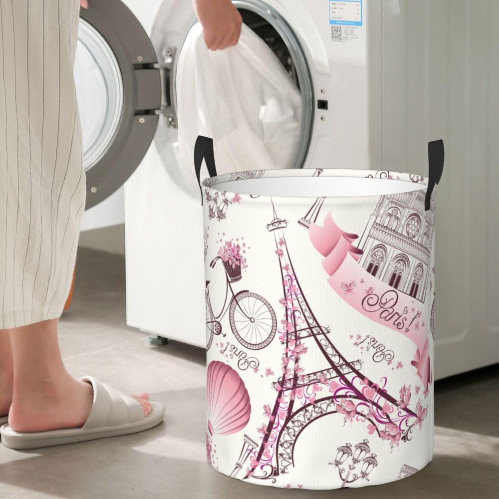 Gbuzozie Paris Eiffel Tower round laundry hamper, standing design with sturdy handles for easy transport.