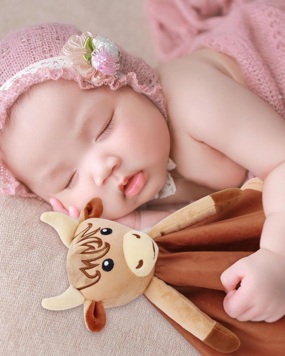 Gicoherero Highland Cow Lovey in a baby's hand for easy gripping.