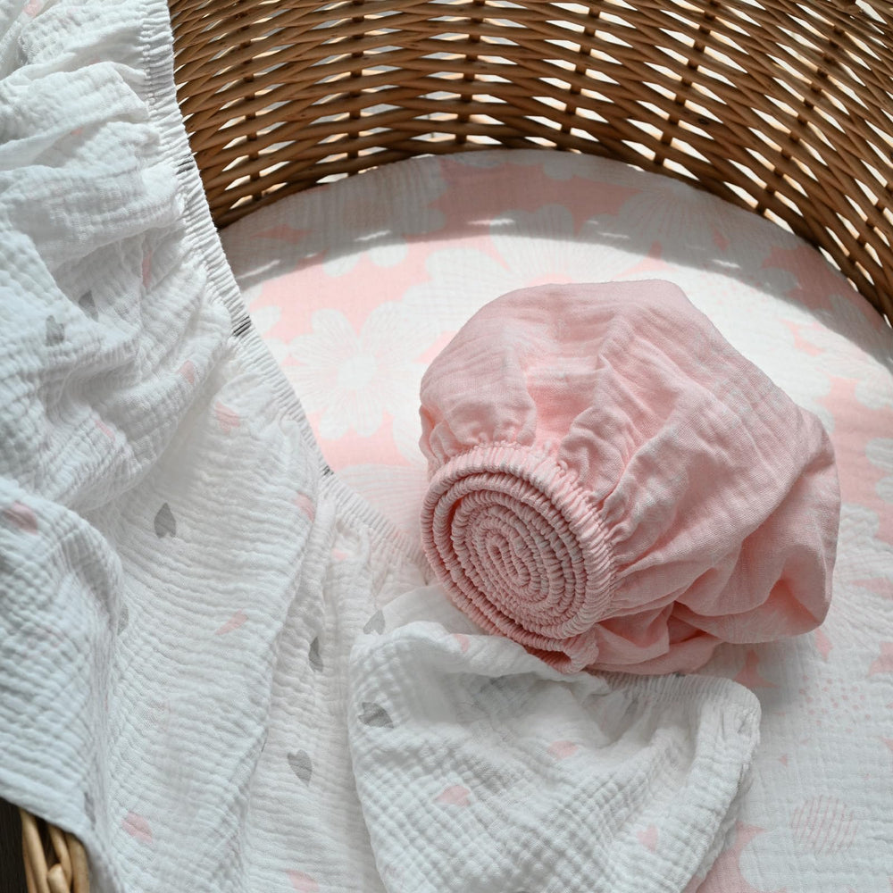 Gllquen bassinet sheets with elastic edge for snug fit demonstration.