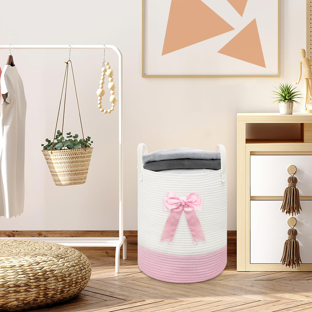 Goodheim pink bow decor basket complements girl’s room storage.