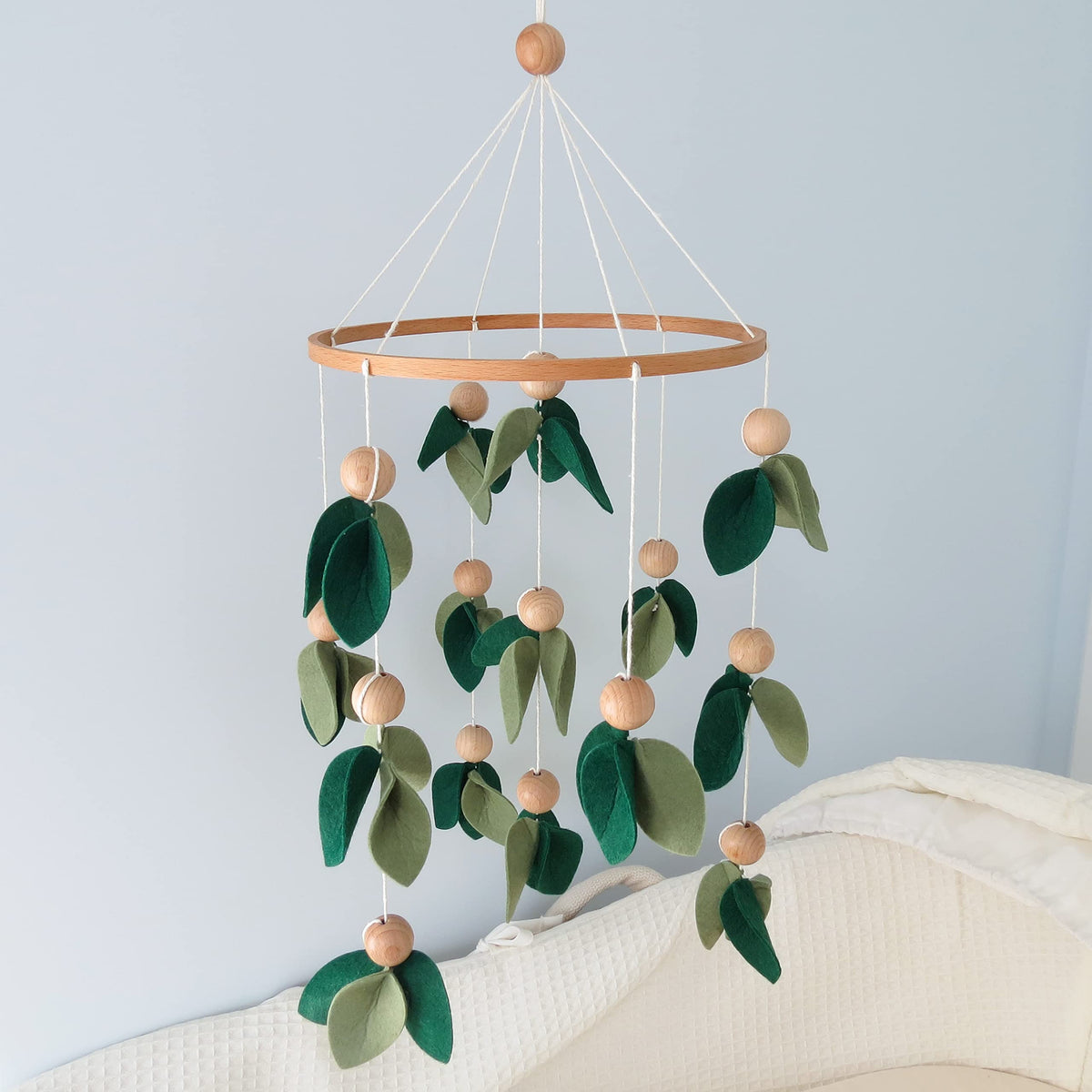 Goukurlsma green leaf crib mobile with wooden beads for calm visual stimulation.