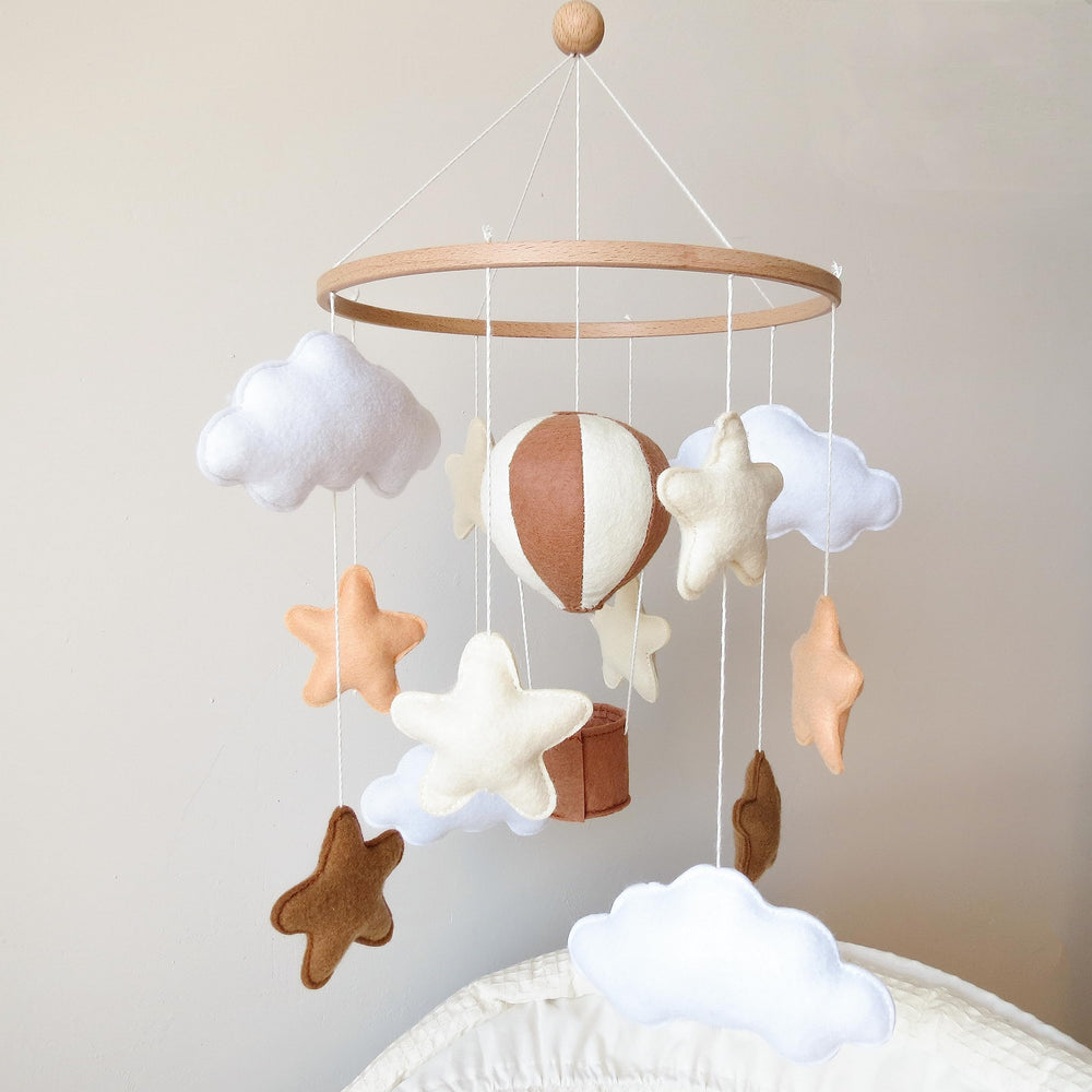 Goukurlsma hot air balloon mobile above crib with beech base for safe visual focus.
