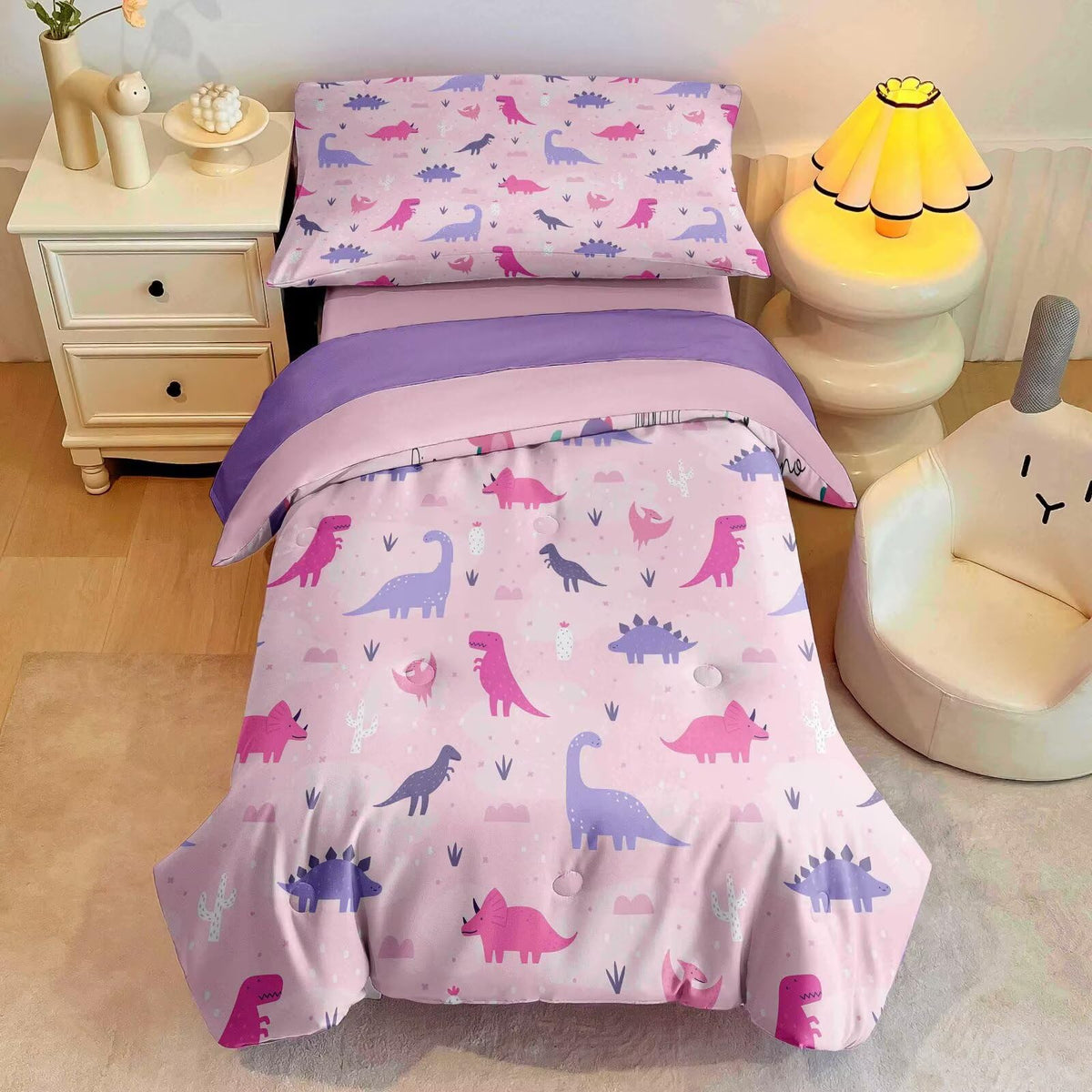 GRAT TIOC pink dinosaur comforter on toddler bed offers soft warmth for bedtime.