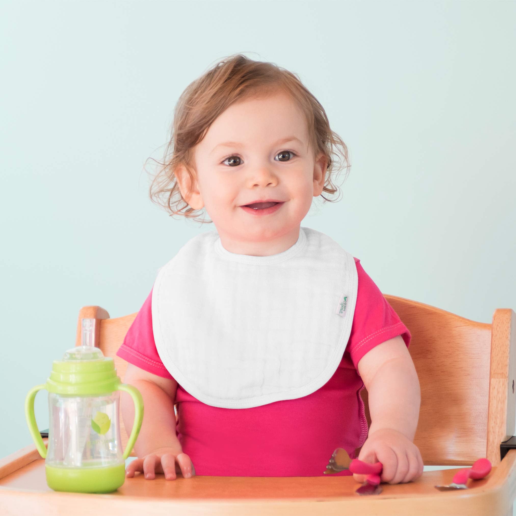 Green Sprouts muslin bibs with adjustable closure fits growing babies securely.