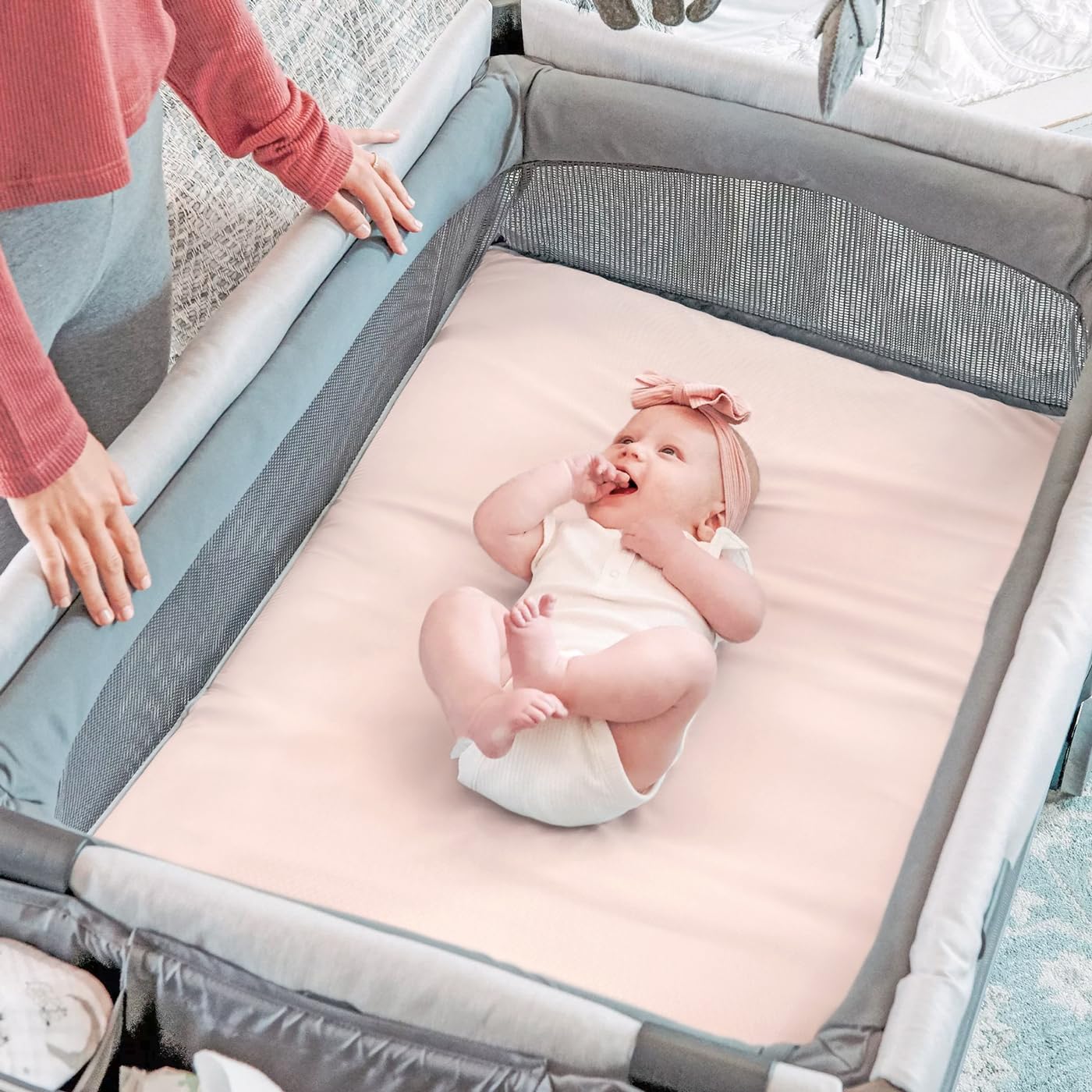Neutral cream and pink GRSSDER sheets add calm to nursery decor.