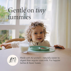 Toddler enjoys Haven A2 formula from a bottle.