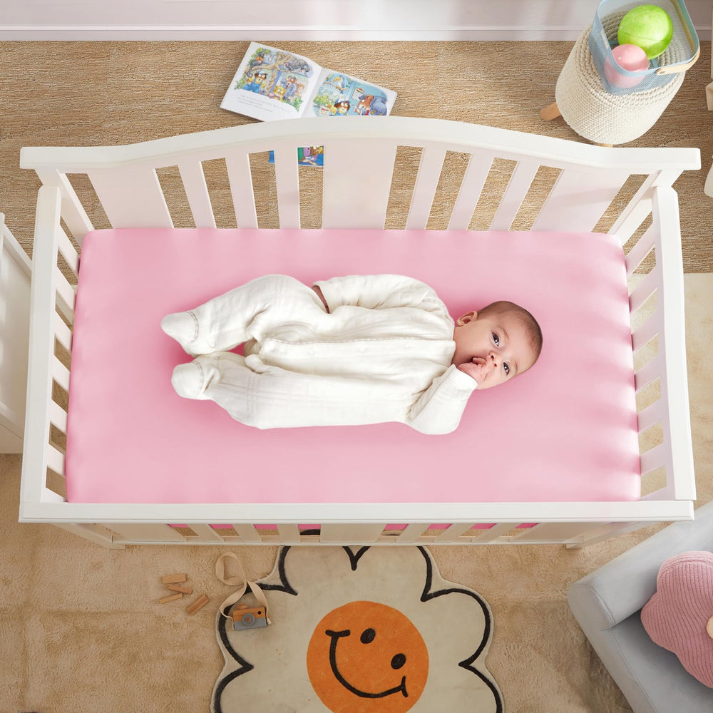 Horbaunal blush pink satin sheet on crib hints at gentle skin contact
