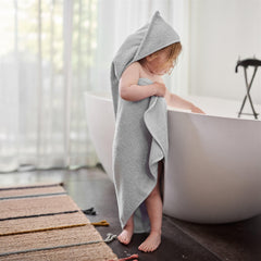 Baby wrapped in Huxie hooded towel after bath for cozy warmth