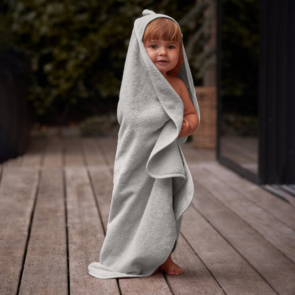 Huxie baby wrapped in towel after bath, snug and secure