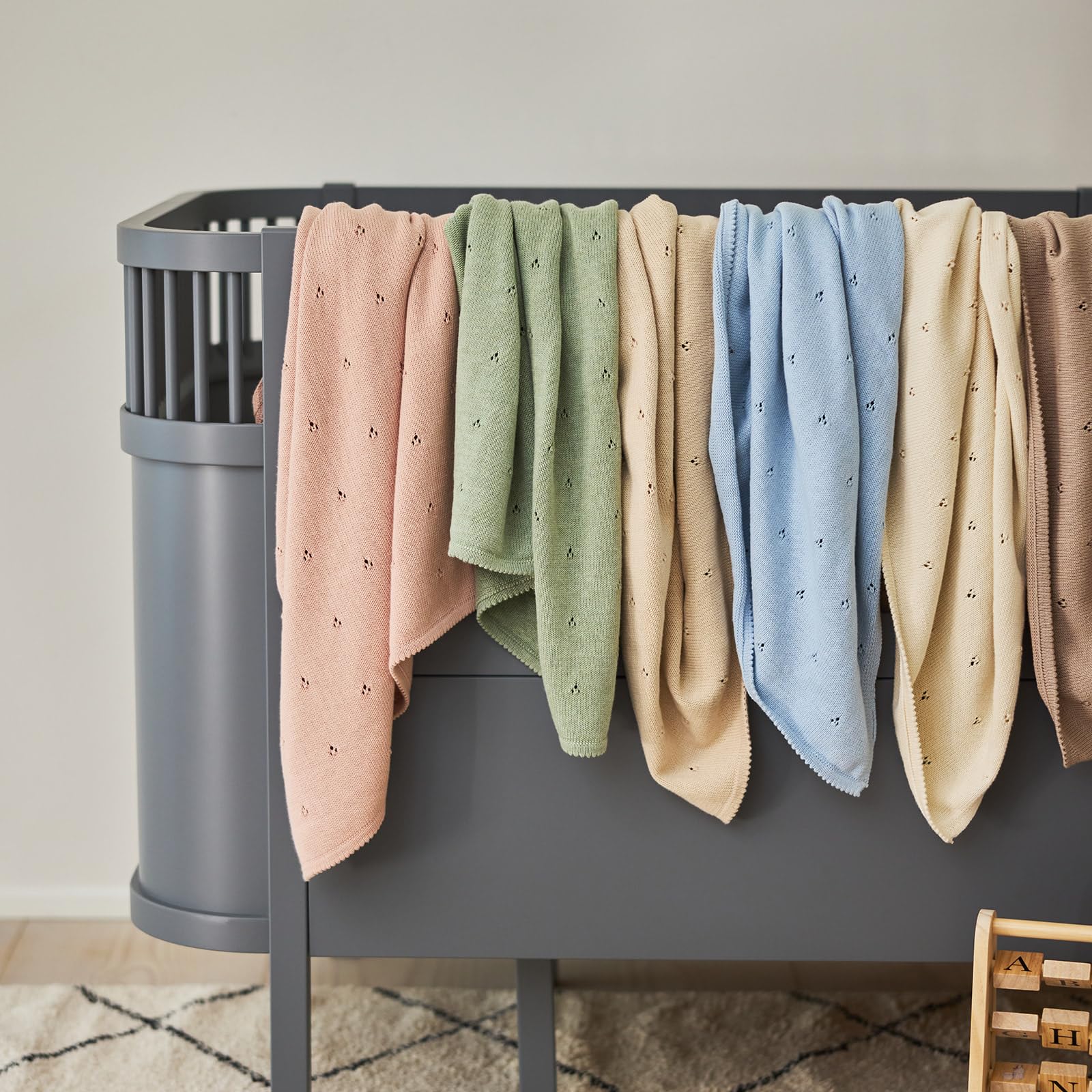 Huxie blanket on crib, ivory, versatile for crib or car seat use.