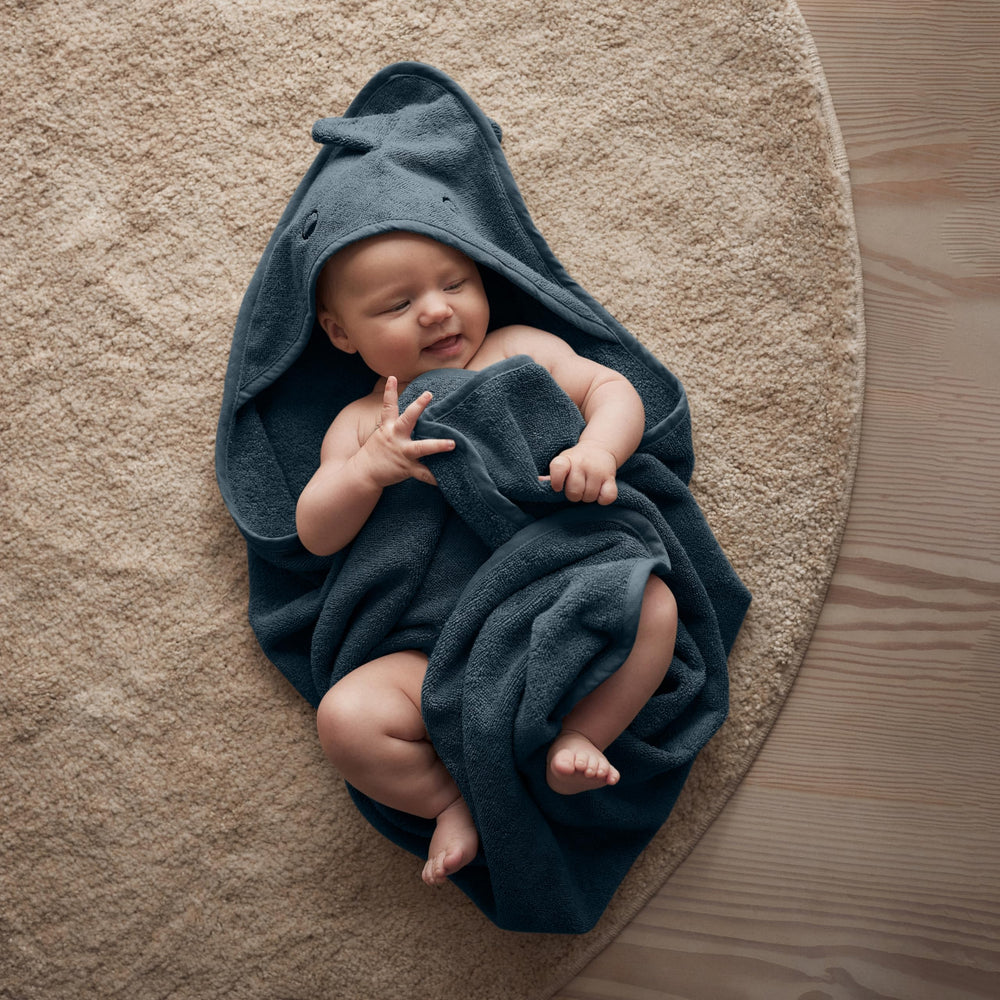 Huxie Dino Tradewinds hooded towel in use on baby, secure wrap