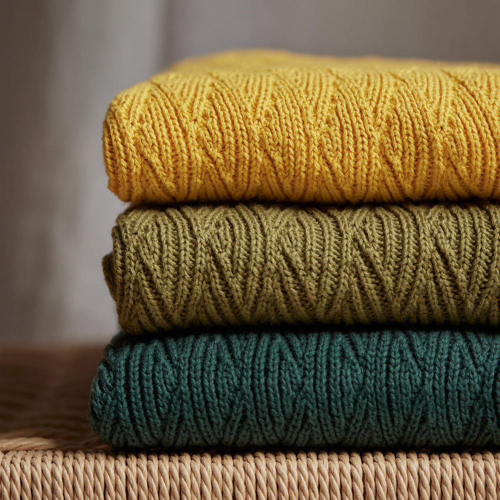 Huxie Waves-Yellow blanket folded beside packaging highlights premium quality.