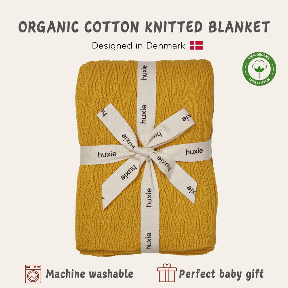 Huxie Waves-Yellow blanket swaddle setup showing secure wrap for nap time.