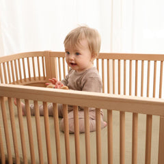 Huxie Sage Green mini crib sheet in a nursery setting with room-ready color