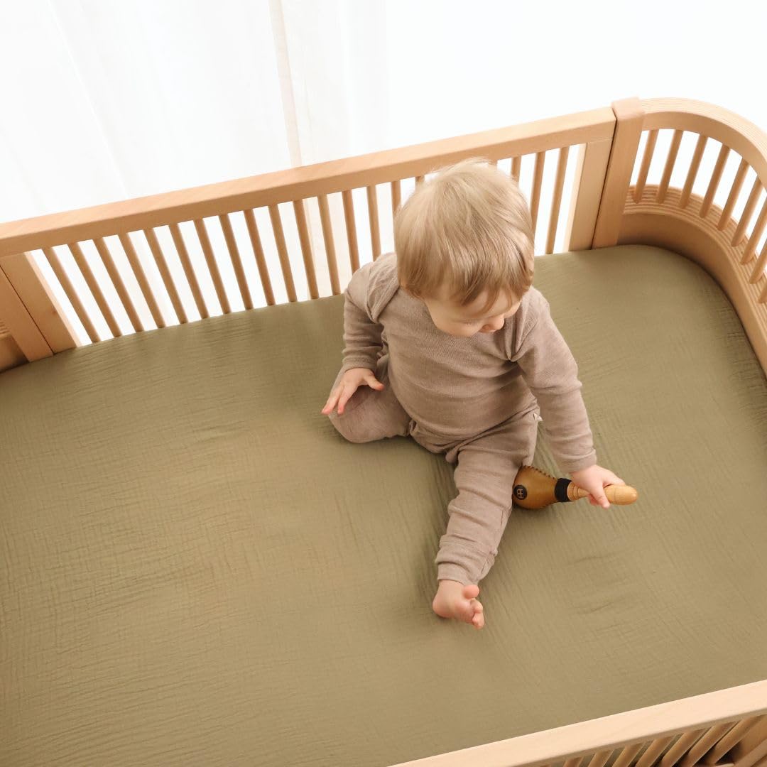 Huxie Sage Green mini crib sheet on pack and play demonstrating snug deep-pocket fit