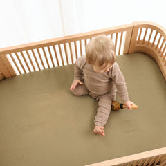 Huxie Sage Green mini crib sheet on pack and play demonstrating snug deep-pocket fit