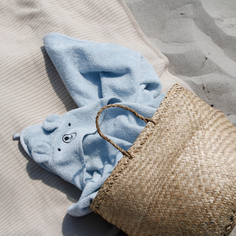 Huxie towel wrapped around a baby after bath for cozy drying.