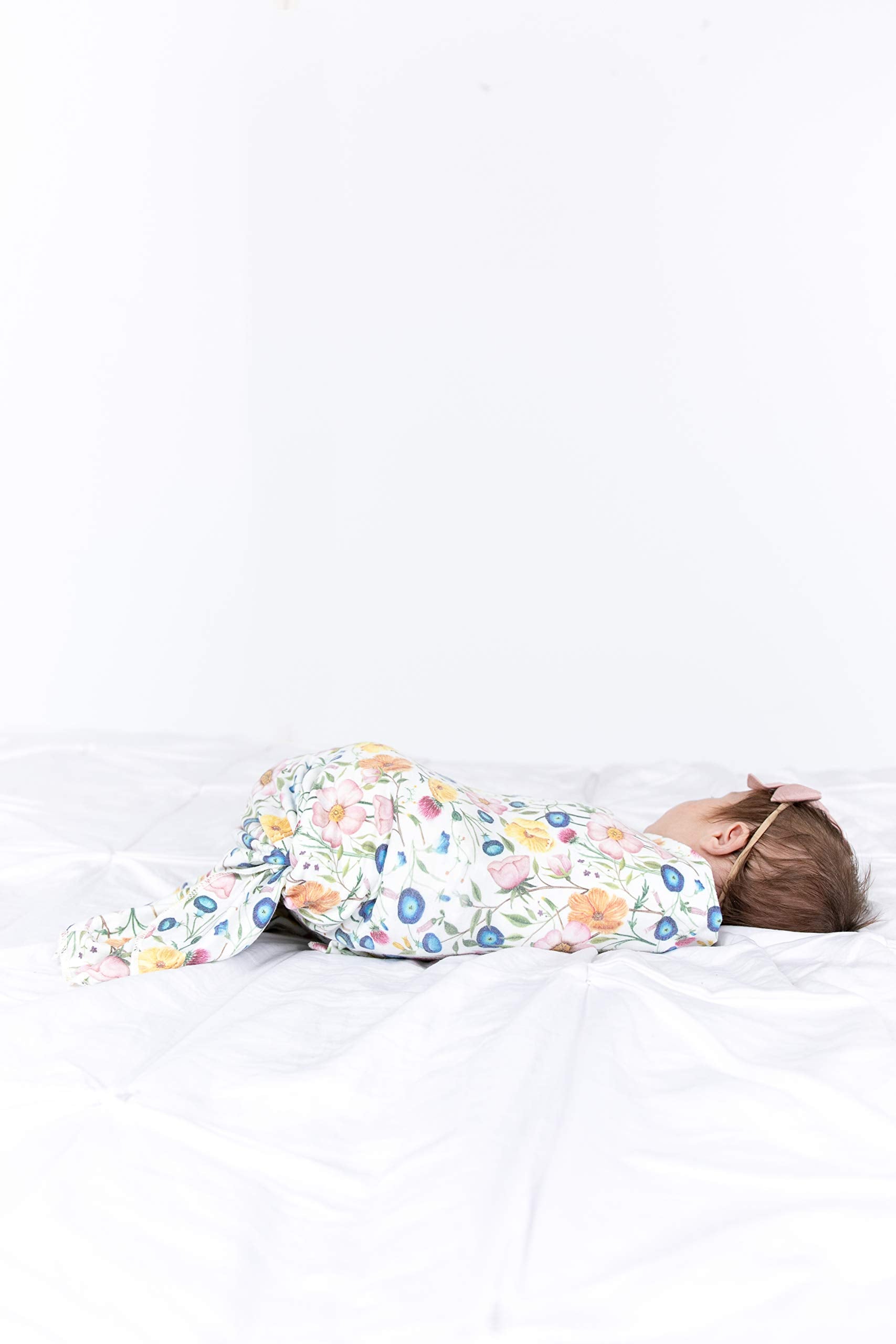 Copper Pearl Isabella swaddle blanket being used with a sleepy newborn for comfort