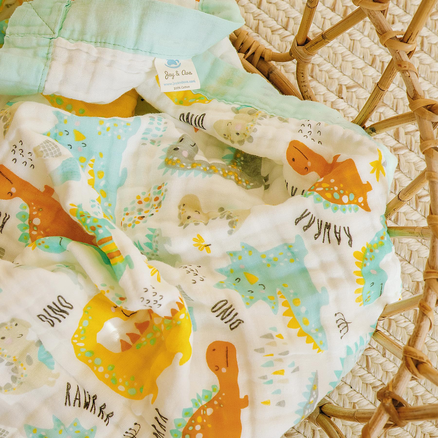 Jay and Ava green dinosaur pattern blanket adds playful nursery decor