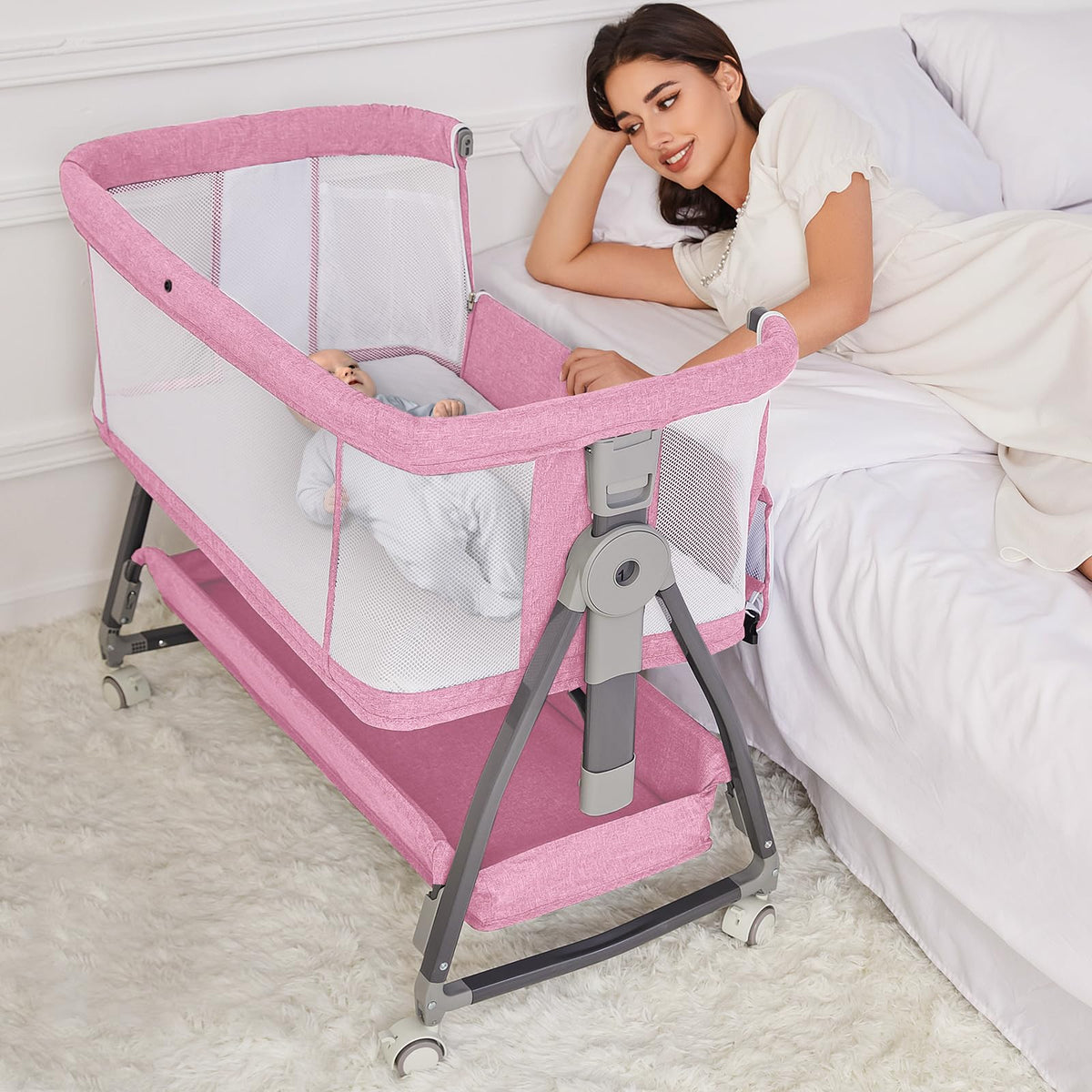 Jixrolyn pink bassinet bedside attachment with wheels for easy nighttime care.