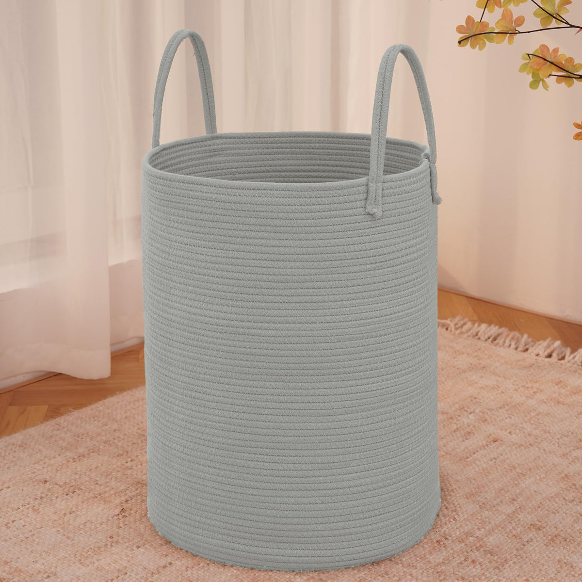 JMvicyroam large woven laundry basket in grey holding blankets and clothes.