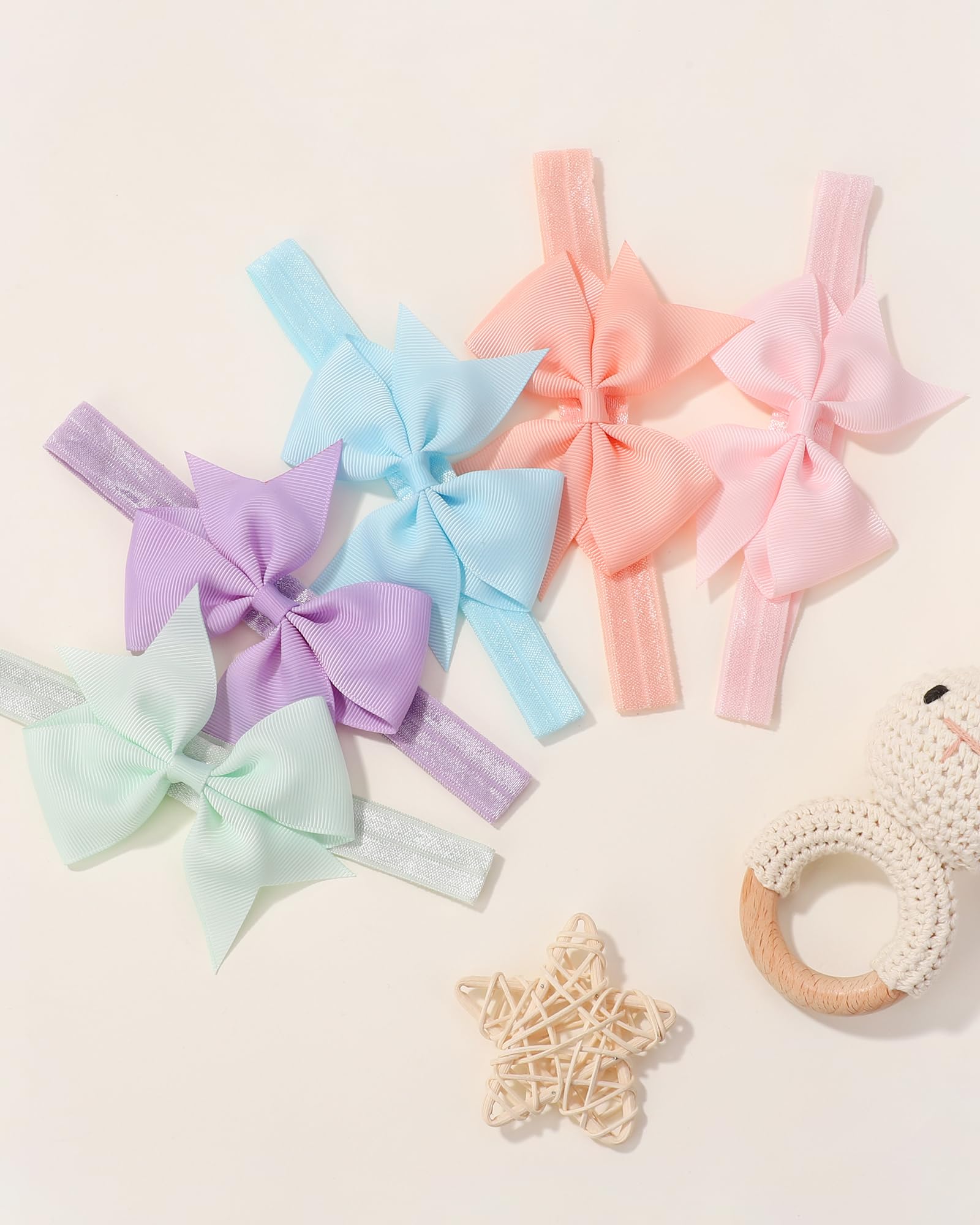 Jollybows 4-inch bows on infant to toddler head, adaptable sizing for growth.