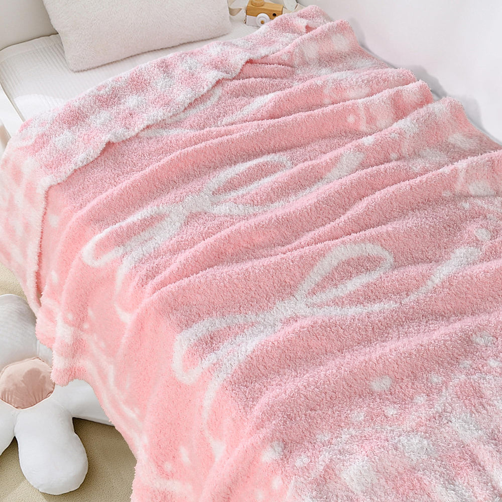 JOOJA pink bow baby blanket soft-knit fabric closeup highlights plush texture.