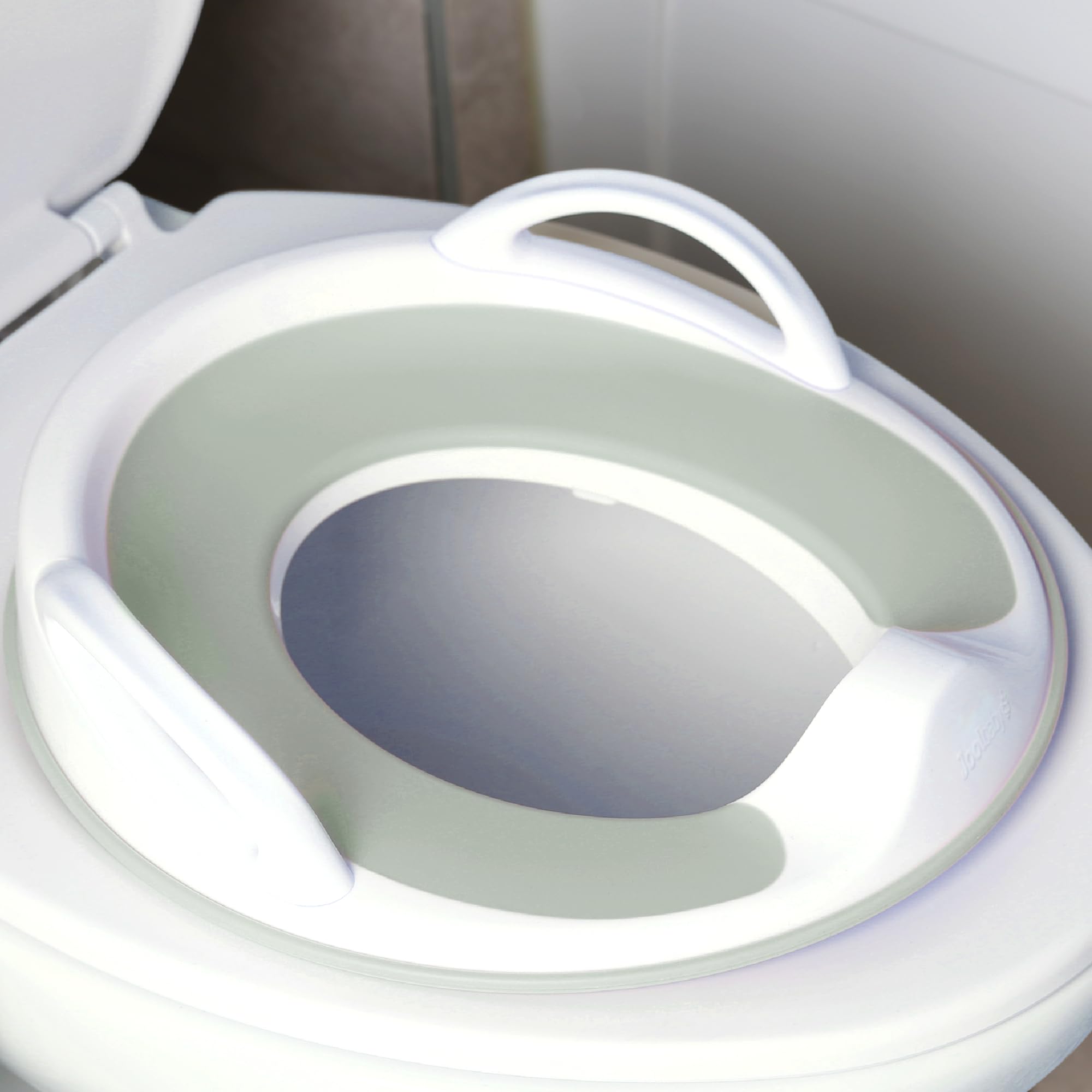 Jool Baby potty seat handles close-up showing grip-friendly design for safe transitions.