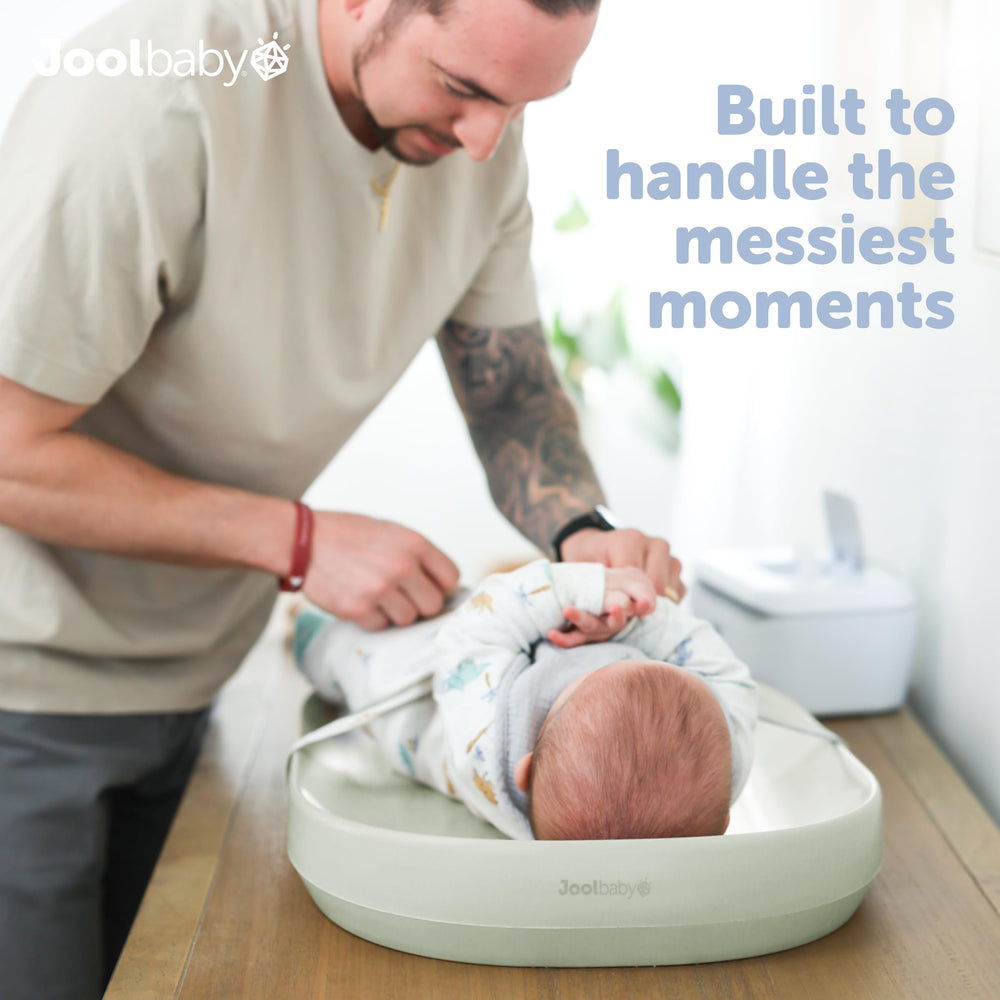 Jool Baby changing pad shows raised sides for secure diaper changes.
