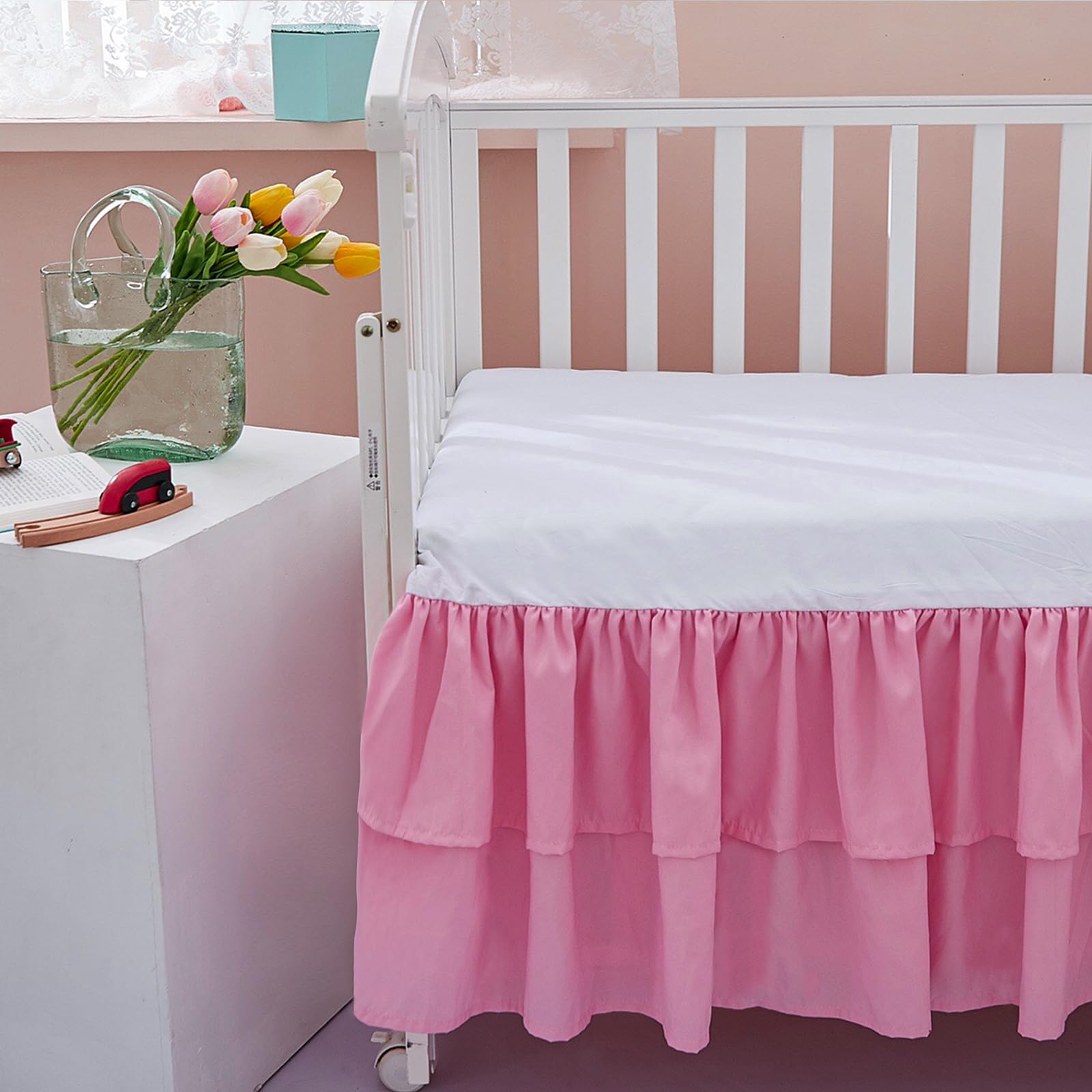 JSD pink crib skirt with 14-inch deep drop hides under-bed storage.