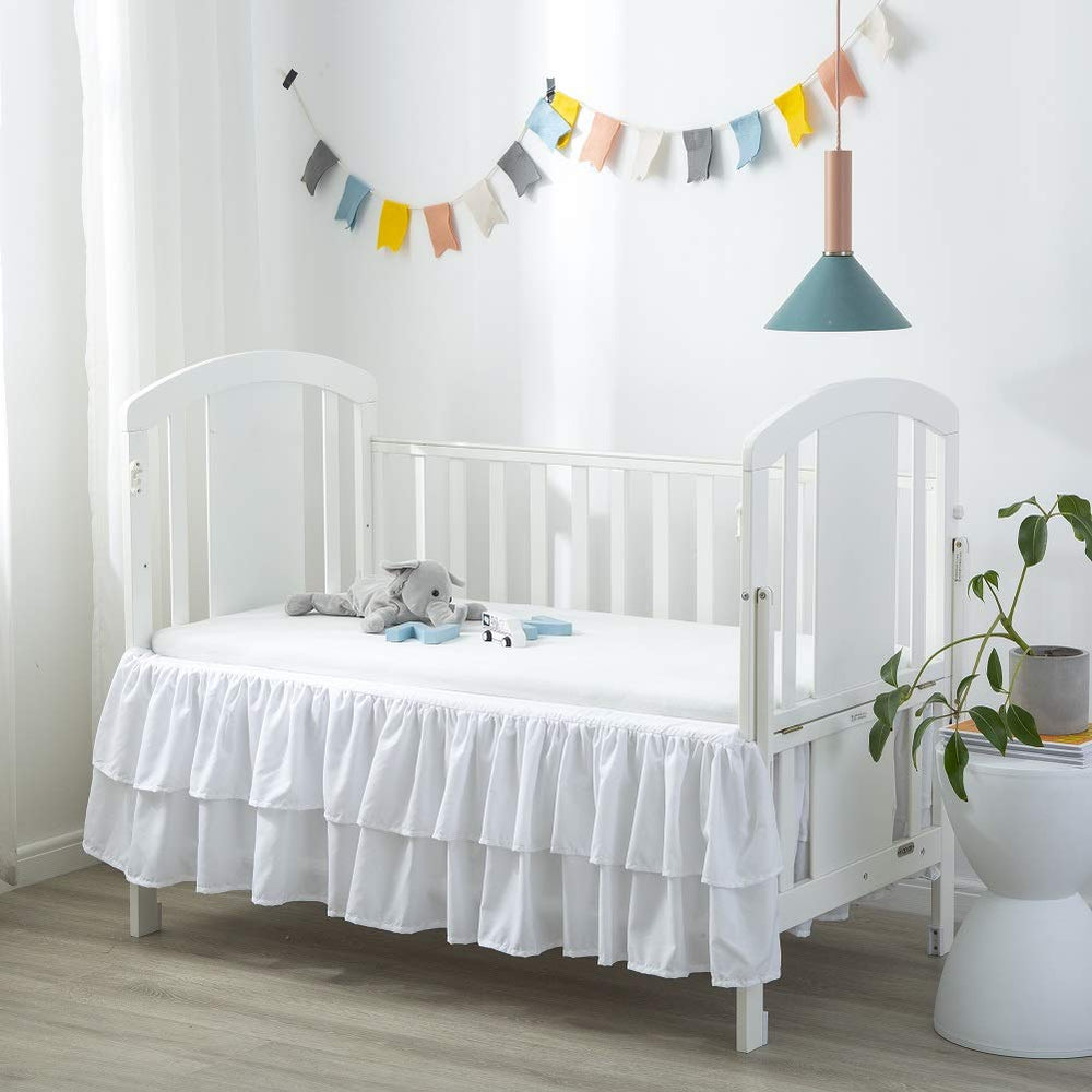JSD white ruffled crib skirt with double layer enhances nursery style and depth