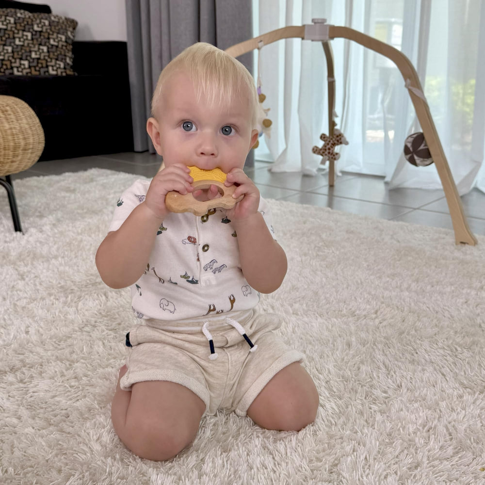 JUNUNA dinosaur teether in blue supports calm teething with textured wood.