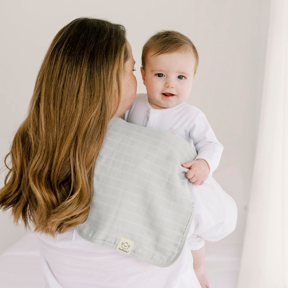 KeaBabies Lumi burp cloth tucked in a diaper bag for on-the-go use.