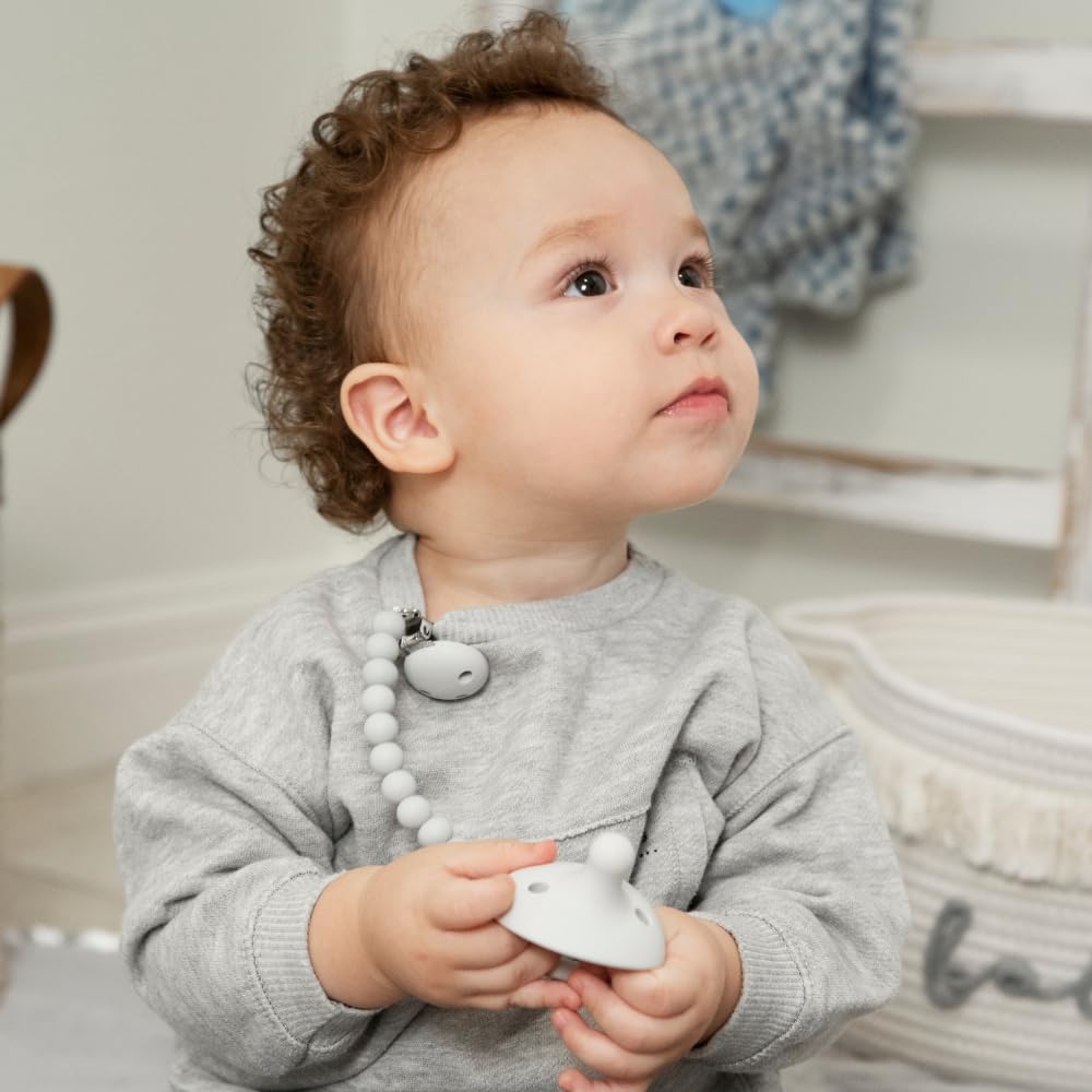 KH Kids Heroes pacifier clip attached to baby clothing.