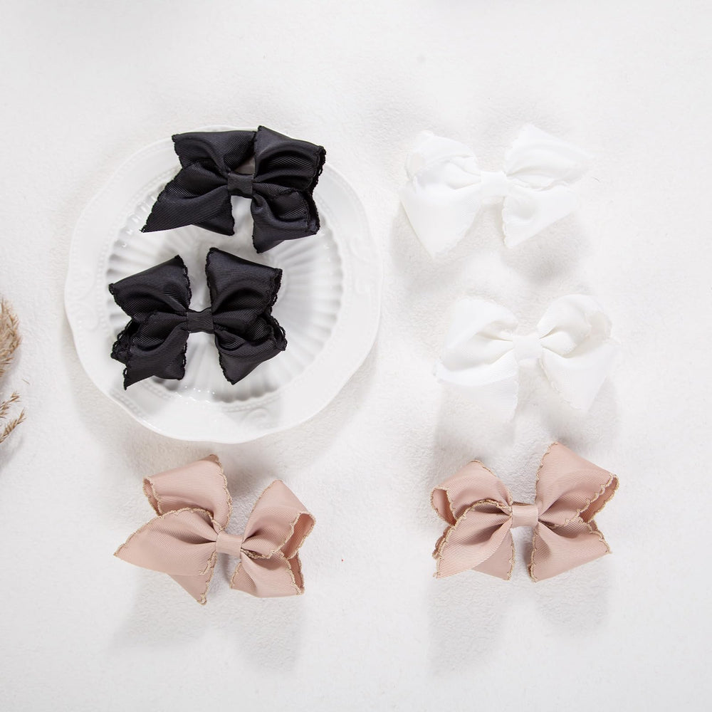 KIDOCHEESE purple grosgrain bow clip helps keep bangs out of photos.