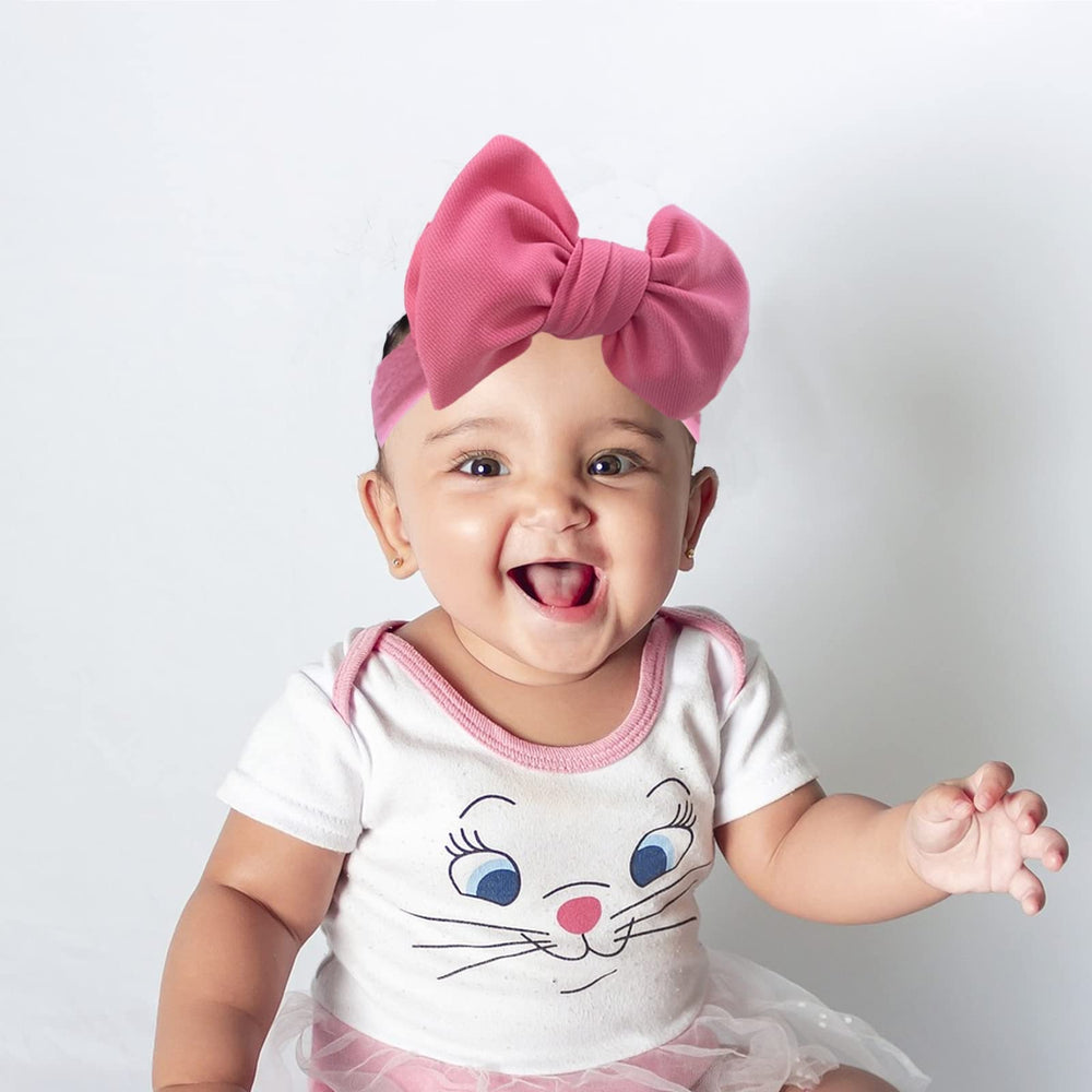 KIDOCHEESE infant wearing headband during a photo session.