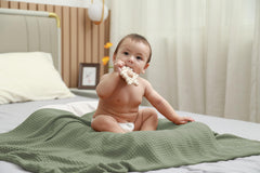 Kloovete Sage blanket shown as a gentle newborn swaddle for cozy comfort.