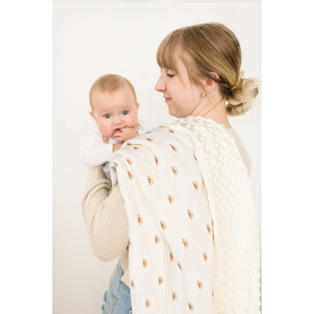 Konssy multi-use blanket shown as receiving blanket and nursing cover.
