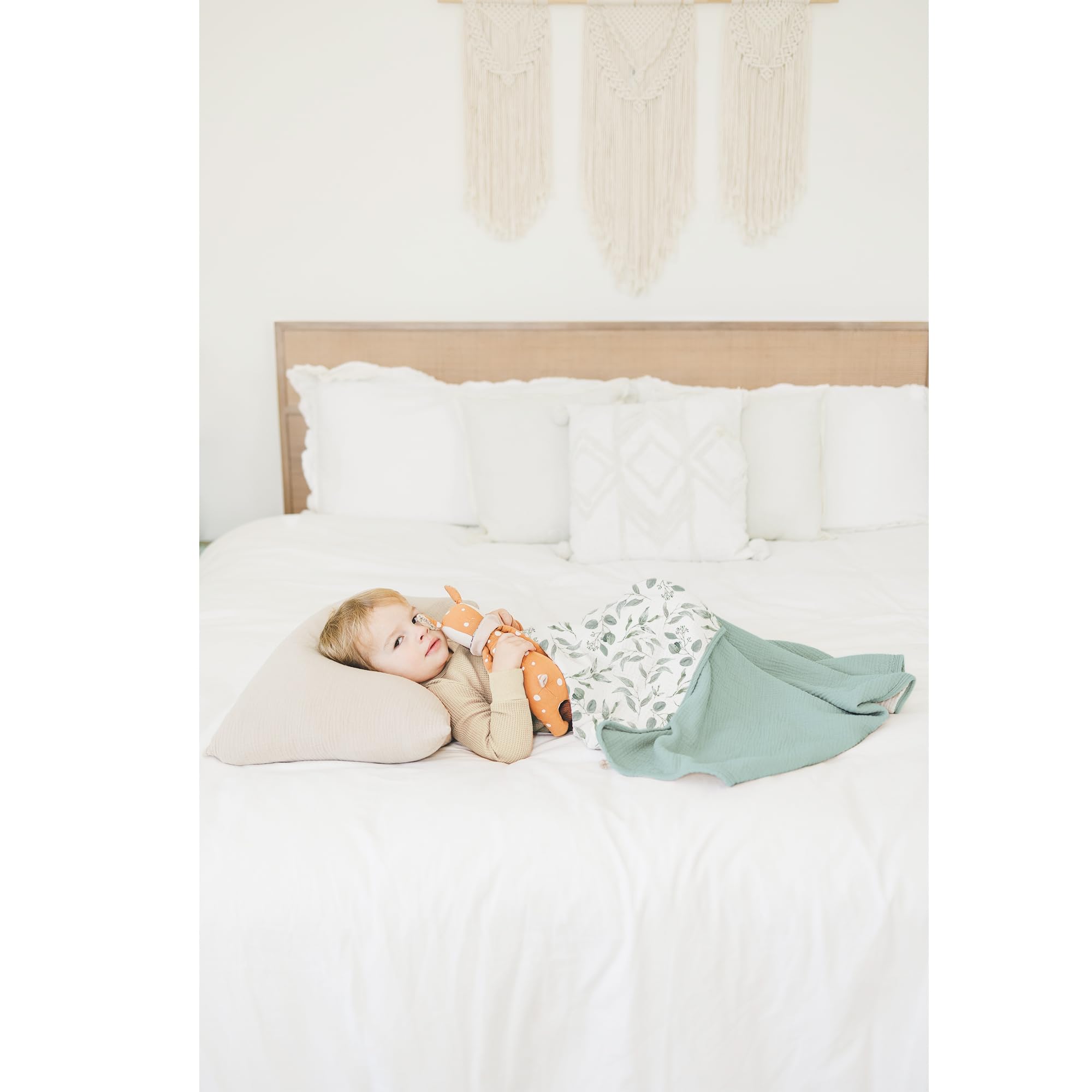 Konssy muslin blanket on nursery decor with gender-neutral green leaves design.